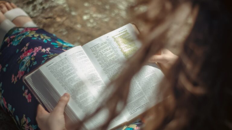 Girl on rock Studying the Bible